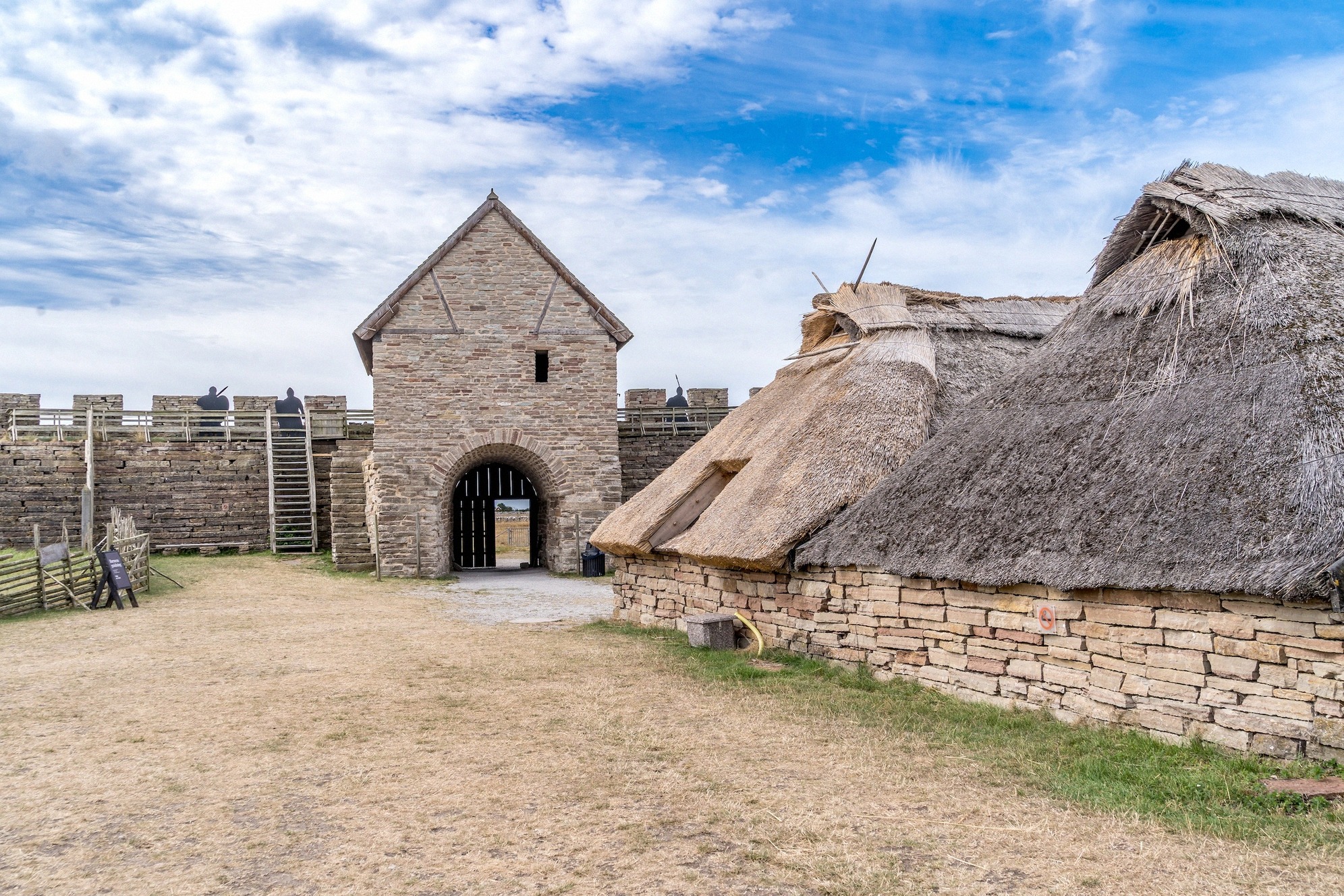 Mittelalterliche Burganlage Eketorp mit charakteristischer Steinmauer und traditionellen Lehmhütten mit Reetdächern.